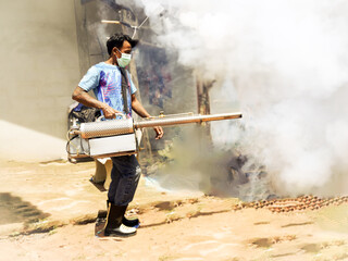 Thai man work fogging to eliminate mosquito for preventing spread dengue fever and zika virus ,...