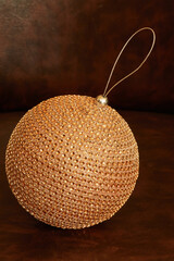 Christmas tree decoration in shape of sphere on leather armchair
