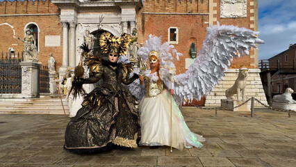 Venice Carnival. People in Venetian carnival masks and costumes on streets of Venice, Italy, Europe...