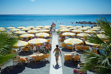  People on coastline beach. Ligurian coast is the national pride of the Italians.