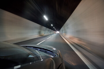 View at illuminated tunnel from right side of moving car.