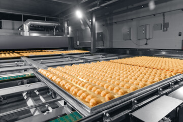 Automatic robot moves French croissants on line conveyor to oven. Concept smart robotic technology in food industry
