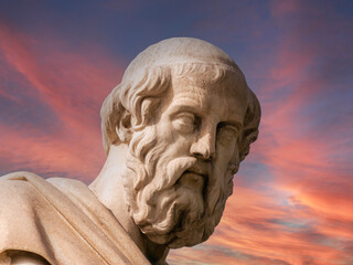 Plato, the famous ancient Greek philosopher under fiery sky, marble statue detail. Travel to...