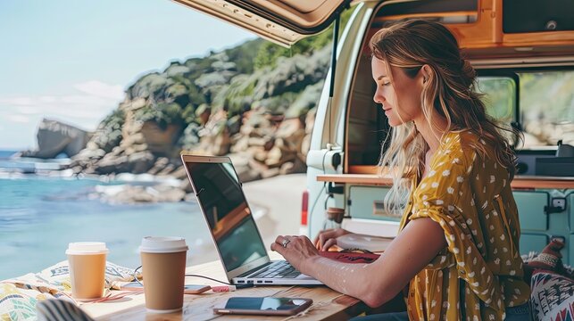 Young woman working outside with camper van. working on laptop at the beach and camping mountain. For banners, covers, backgrounds about work while traveling. Freelance work
