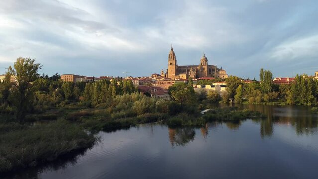 View of the Salamanca cathedral reflected in the Tormes river in Spain.