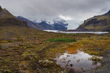 Traveling and exploring Iceland landscapes and famous places. Autumn tourism by Atlantic ocean and mountains. Outdoor views on beautiful cliffs and travel destinations. Svinafellsjokull glacier.