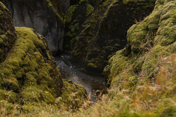 Traveling and exploring Iceland landscapes and famous places. Autumn tourism by Atlantic ocean and mountains. Outdoor views on beautiful cliffs and travel destinations. Fjadrargljufur Canyon.
