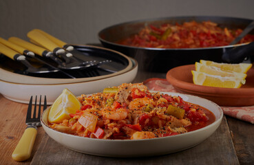 Spicy chicken and prawns in a rich sauce garnished with a lemon slice.