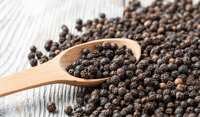 black pepper on wooden spoon