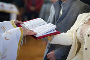 The newlyweds hold the Gospel, which is read by the priest during the wedding ceremony. The photo...