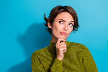 Photo of minded confused girl wear khaki clothes arm touch chin look up empty space hmm dilemma...