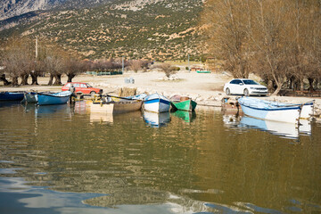 Fototapeta na wymiar Decorated day-trip boats in Isikli Lake in Denizli's Civril district. Isıkli Lake is flooded with visitors during lotus time. It is also a popular lake for hunters.