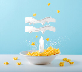 Aquarius zodiac sign made of milk levitates over breakfast plate of cornflakes and milk