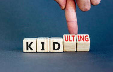 Kid or kidulting symbol. Concept words Kid or Kidulting on wooden cubes. Beautiful grey table grey...