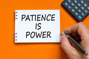 Patience is power symbol. Concept words Patience is power on beautiful white note. Beautiful orange background. Businessman hand. Calculator. Business and patience is power concept. Copy space.