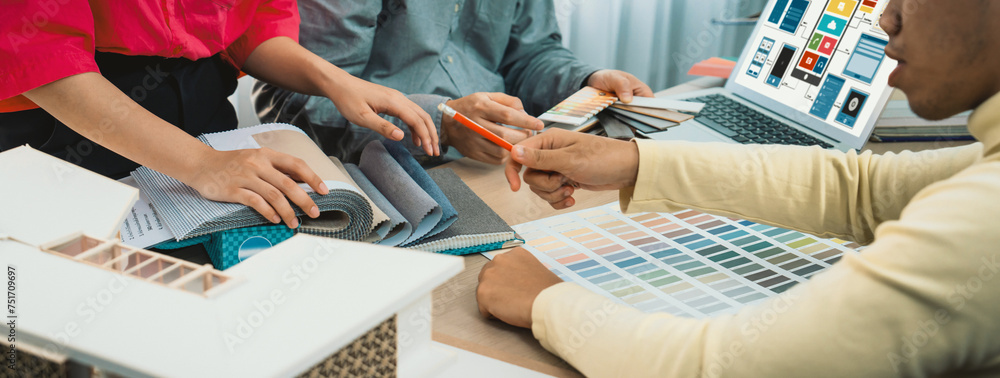 Poster cropped image of interior designer team presents color by using color swatches while laptop displaye