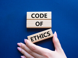 Code of ethics symbol. Concept words Code of ethics on wooden blocks. Beautiful deep blue...