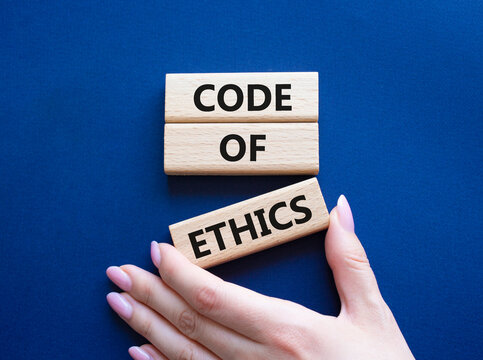 Code of ethics symbol. Concept words Code of ethics on wooden blocks. Beautiful deep blue background. Businessman hand. Business and Code of ethics concept. Copy space.