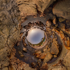 blue sky ball in middle of swirling asphalt road or stone field. Inversion of tiny planet transformation of spherical panorama 360 degrees. Spherical abstract view. Curvature of space.