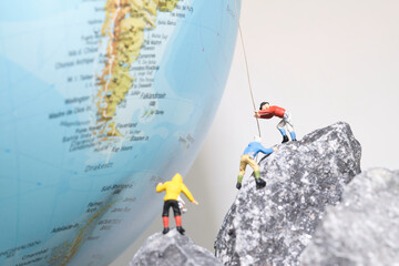 Bergsteiger klettern auf einen Globus, miniaturfiguren fotografie - obrazy, fototapety, plakaty