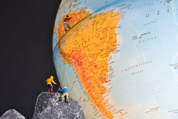 Bergsteiger klettern auf einen Globus, miniaturfiguren fotografie