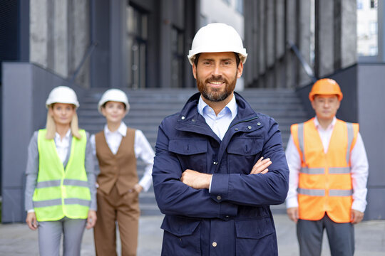 Professional male architect smiling in hard hat with diverse construction team in high visibility vests. - Powered by Adobe