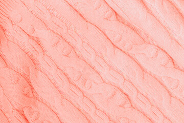 Knitted texture, Coral color with pattern, woolen knit fabric closeup. Background