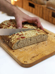 chef cortando con cuchillo un pan de pizza en una tabla de madera