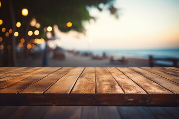 Wooden table top with blurry beach in the backdrop at dusk, empty wooden table with blurry beach...