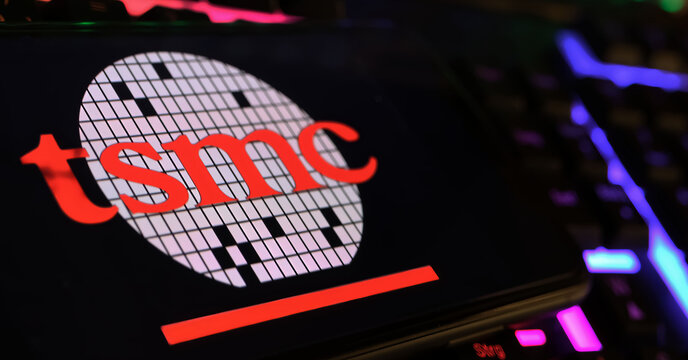 Viersen, Germany - February 9. 2024: Closeup of smartphone with logo lettering of Taiwan TSMC semiconductor manufacturing on computer keyboard