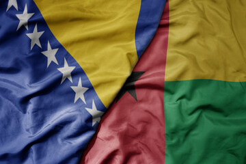 big waving national colorful flag of guinea bissau and national flag of bosnia and herzegovina.
