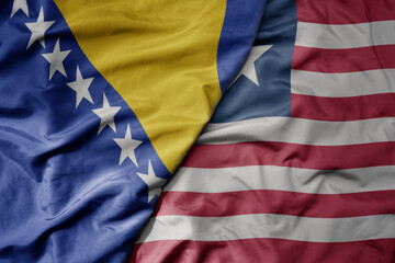 big waving national colorful flag of liberia and national flag of bosnia and herzegovina.