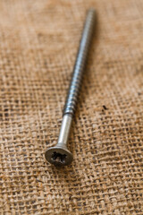 Aged and Slightly Rusted Screw Lying on a Fabric