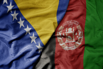 big waving national colorful flag of afghanistan and national flag of bosnia and herzegovina.