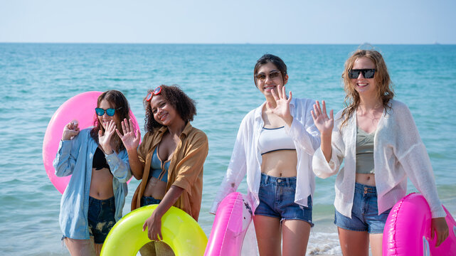 Group of diverse young women smiling on a sunny beach. Youth Friends Enjoying Sea Splash Together.