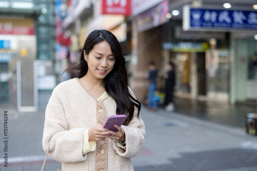 Wall mural Woman use mobile phone in the street at Taipei city