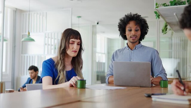 Low angle of Friendly business man showing project to transgender woman at cafe office.&nbsp;&nbsp;