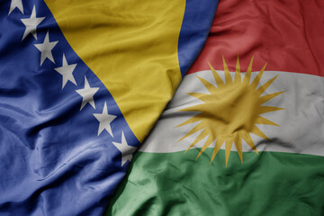 big waving national colorful flag of kurdistan and national flag of bosnia and herzegovina.