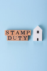 The inscription Stamp Duty made of wooden cubes on a plain background