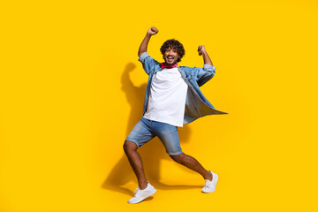 Fototapeta na wymiar Full size photo of nice young male raise fists dancing dressed stylish denim outfit red scarf isolated on yellow color background