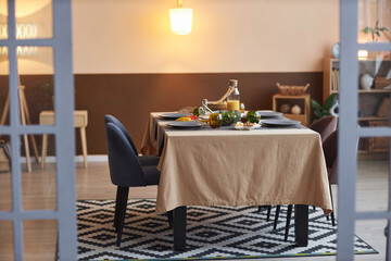Full length shot of small dinner table with no people in cozy living room shot through glass doors copy space 