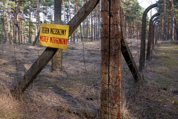 Ogrodzony w środku lasu teren wojskowy na który obowiązuje zakaz wstępu. - obrazy, fototapety, plakaty