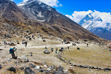 Trekkers return down the Khumbu valley after completing the Everest base camp trek with Ama Dablam...