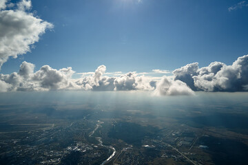 Aerial view from airplane window at high altitude of earth covered with puffy cumulus clouds...