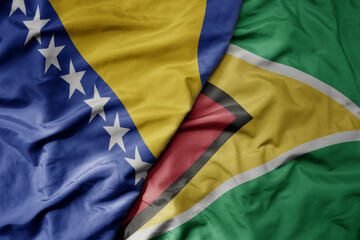 Fototapeta premium big waving national colorful flag of guyana and national flag of bosnia and herzegovina.