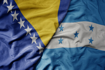 big waving national colorful flag of honduras and national flag of bosnia and herzegovina.