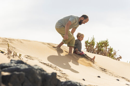 Playful family moments on a sandy beach dune