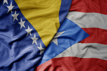 big waving national colorful flag of puerto rico and national flag of bosnia and herzegovina.