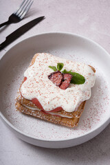 Belgian waffles with strawberry confit and cream sauce on grey background