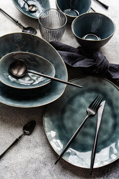 Elegant ceramic tableware and cutlery on textured background